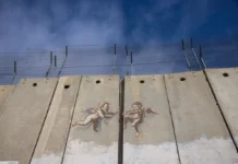 इजरायलको बिरोध गरेपछि यिनको आर्किटेक्चर पुरस्कार फिर्ता लिइयो Evolution of Cherub Wall by Banksy is pictured on Israeli separation wall on December 23, 2023 in Bethlehem, West Bank. Last month, Christian Palestinian leaders here called off public Christmas celebrations, citing the effects of the ongoing war in Gaza. Regarded by Christians as the birthplace of Jesus, Bethlehem is usually bustling with foreign tourists this time of year, with streets full of holiday decoration and vendors selling ornaments and festive figurines. Israel's war against Hamas that was sparked by the Oct. 7 attacks has also made life more volatile in the West Bank. Israeli forces here have stepped up raids on alleged militants, police have clashed with protesters, and there has been a rise in violent attacks on Palestinians by Israeli settlers. (Photo by Maja Hitij/Getty Images)